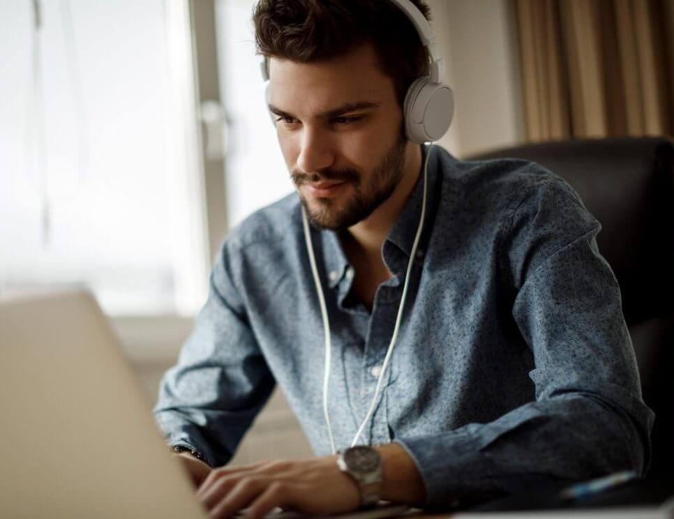 Mann am PC mit Kopfhörer für Mitarbeiter Recruiting